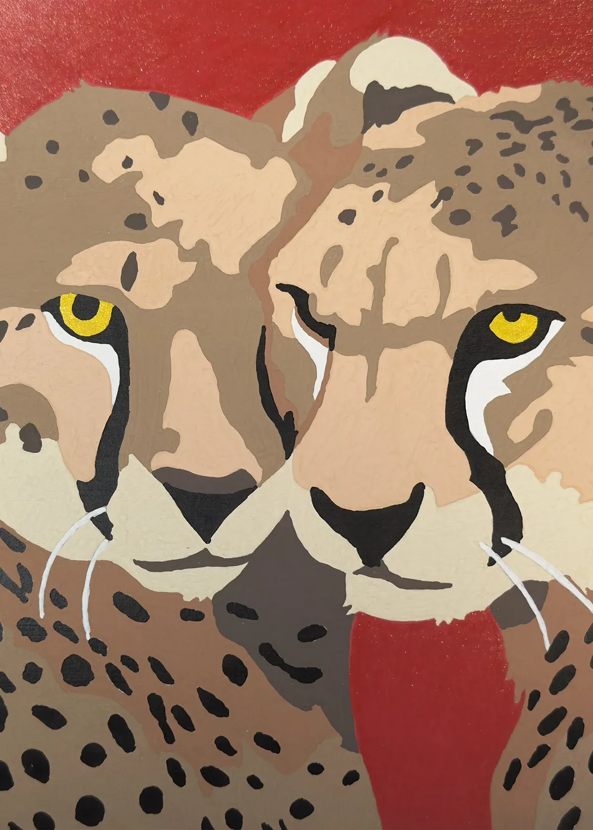 Completed colour-by-numbers page featuring a pair of cheetahs together, with detailed spotted coats, bright yellow eyes and a red background.